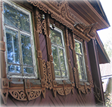 Maison villageoise en bois ciselée de cadres autour des fenêtres